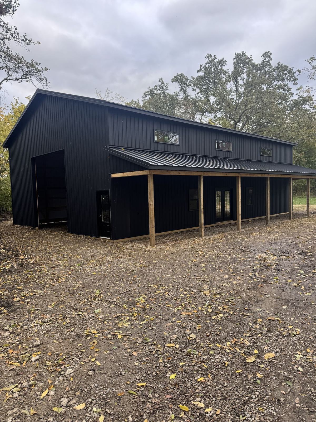 Black metal building with a timber porch