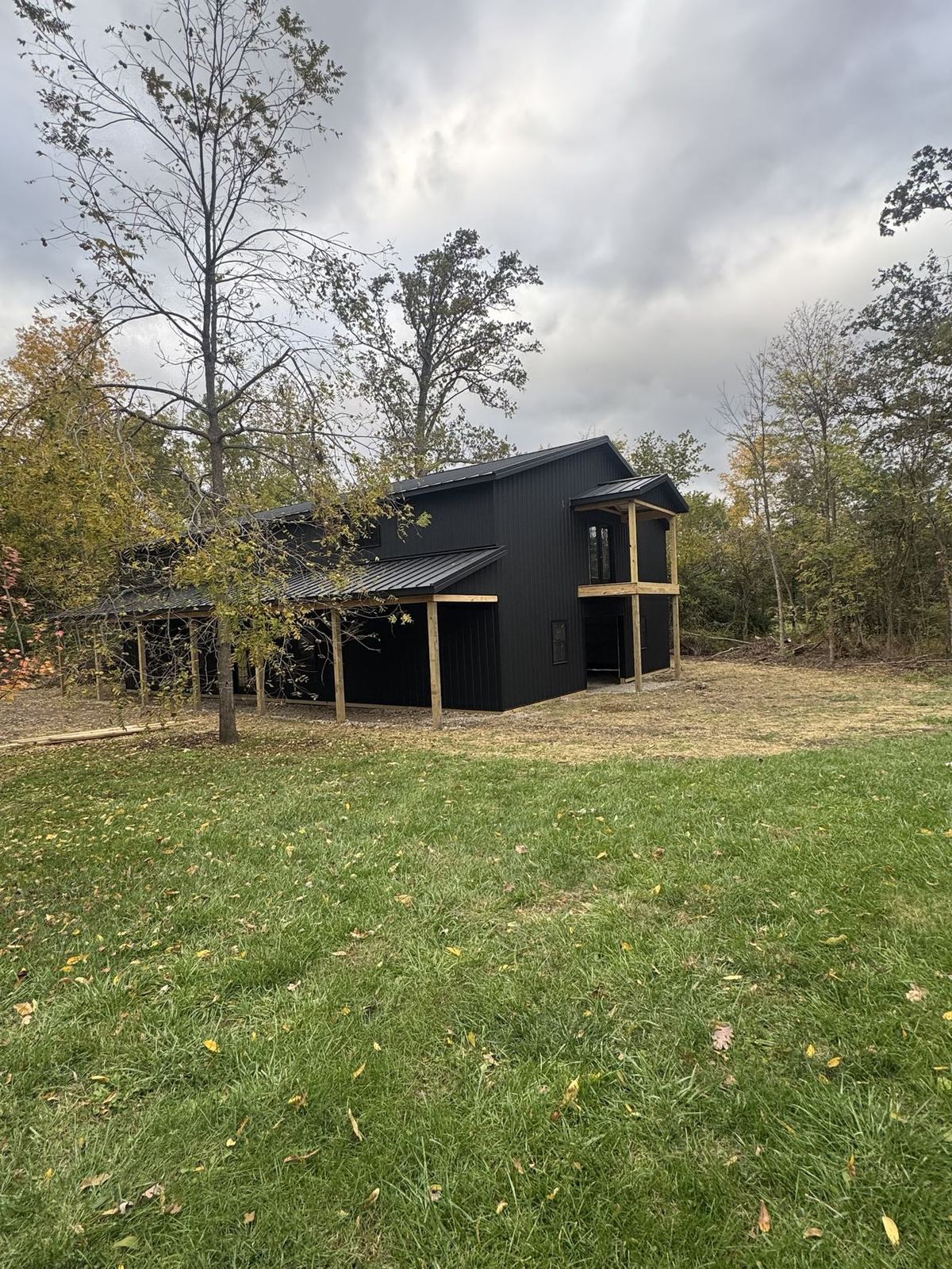 Black two-story barn with a loft porch