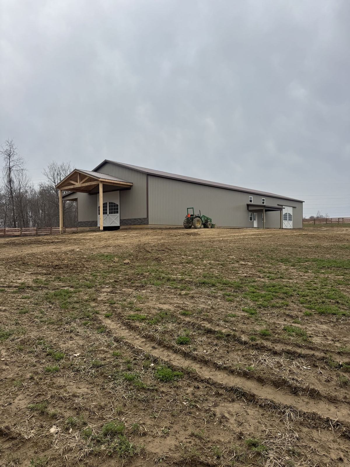 Long gray agricultural barn with timber entry porches