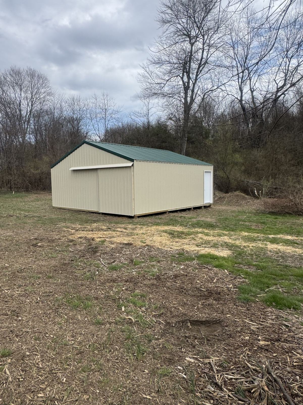 Tan garage with a green roof