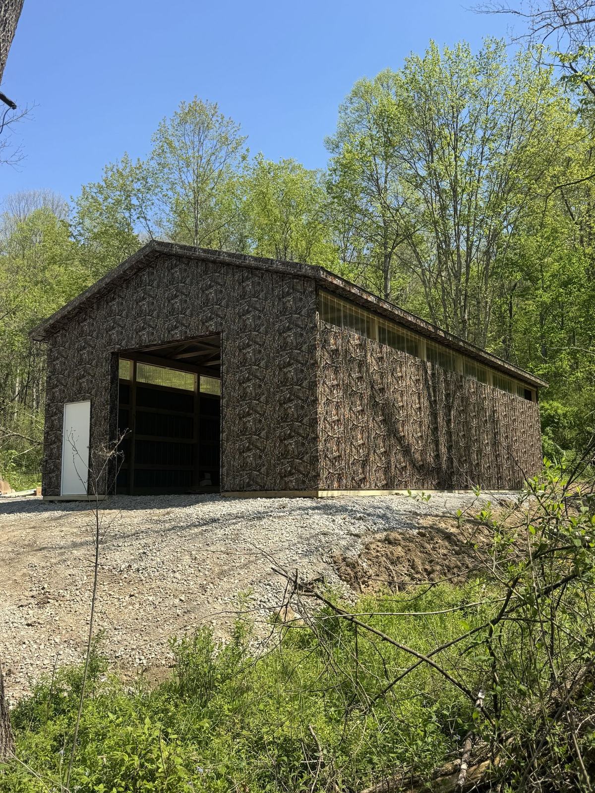 Camouflage-sided barn in the woods