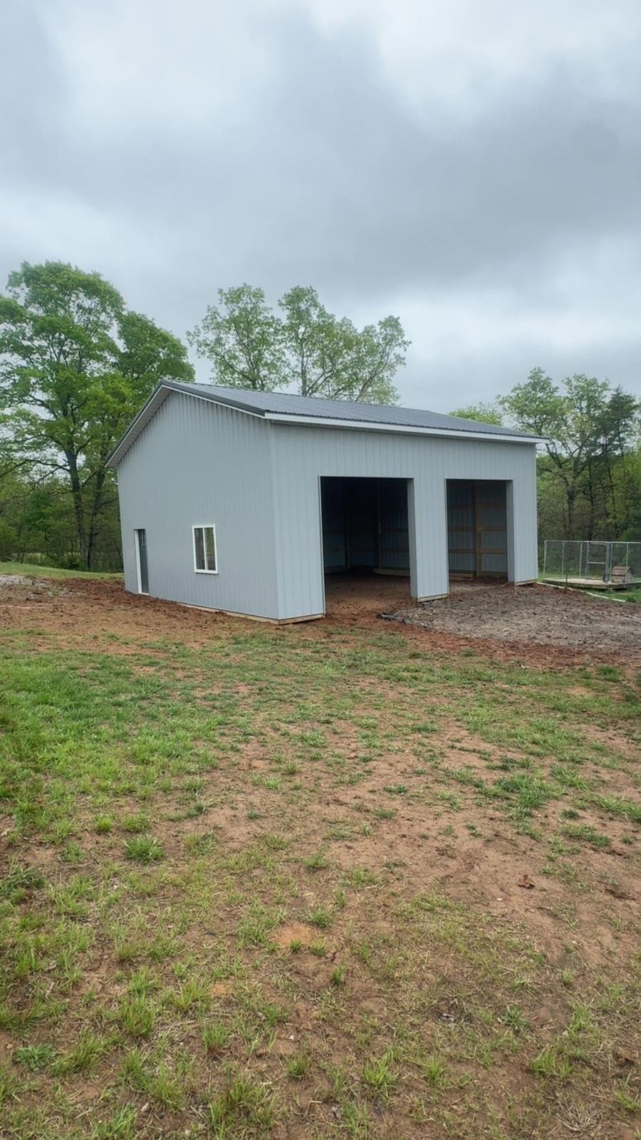 Light gray barn with three bays